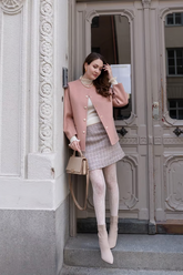 a lady in a pink double faced coat and a knitted skirt